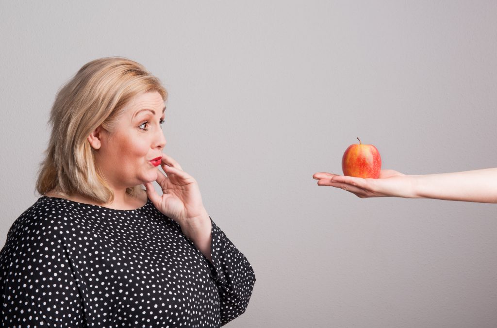 Weight Loss Surgery in Turkey's Consequences 3 a female hand giving an apple to an attractive ove A2K8LMC min