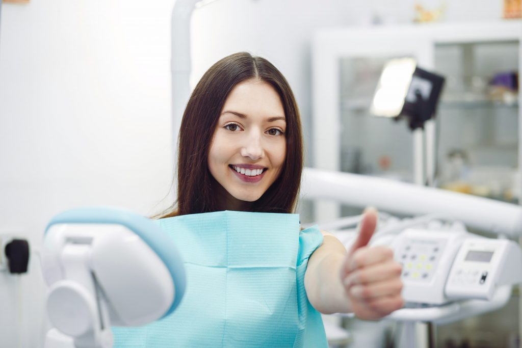 Advantages of Dental Implants in Turkey 3 girl showing thumbs up at a reception at the denti X953HBT min