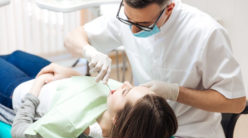 profesionāls zobārsts veic zobu pārbaudi sievietei P9R4X32 min