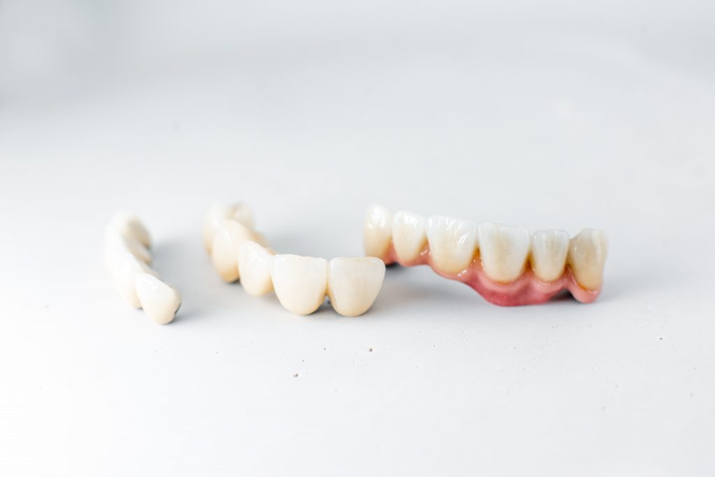 The Pros and Cons of Different Types of Veneers in Turkey 2 dental crowns on the white background PML83NN min