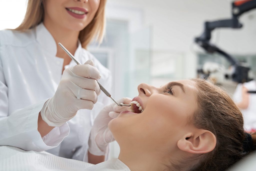 dentist treating woman 39 s teeth in dentistry RLVW39T min