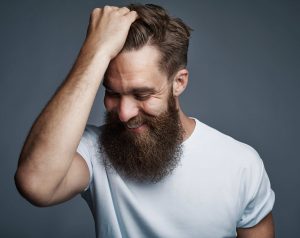 laughing bearded man holding hair and laughing 3DLGZ7V min
