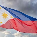 philippines flag waving against cloudy sky B5GKH5Q min