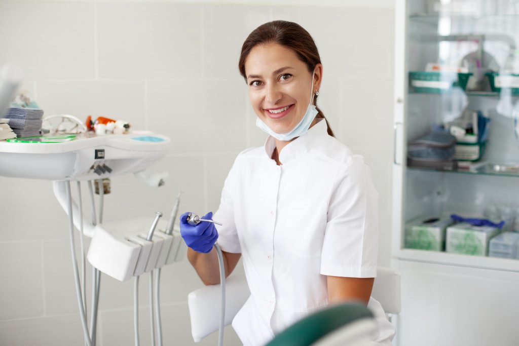 Dental Implant Prices in London Clinics and Hospitals 2 woman dentist treats a patient a woman in a mask s 3FW56LX min