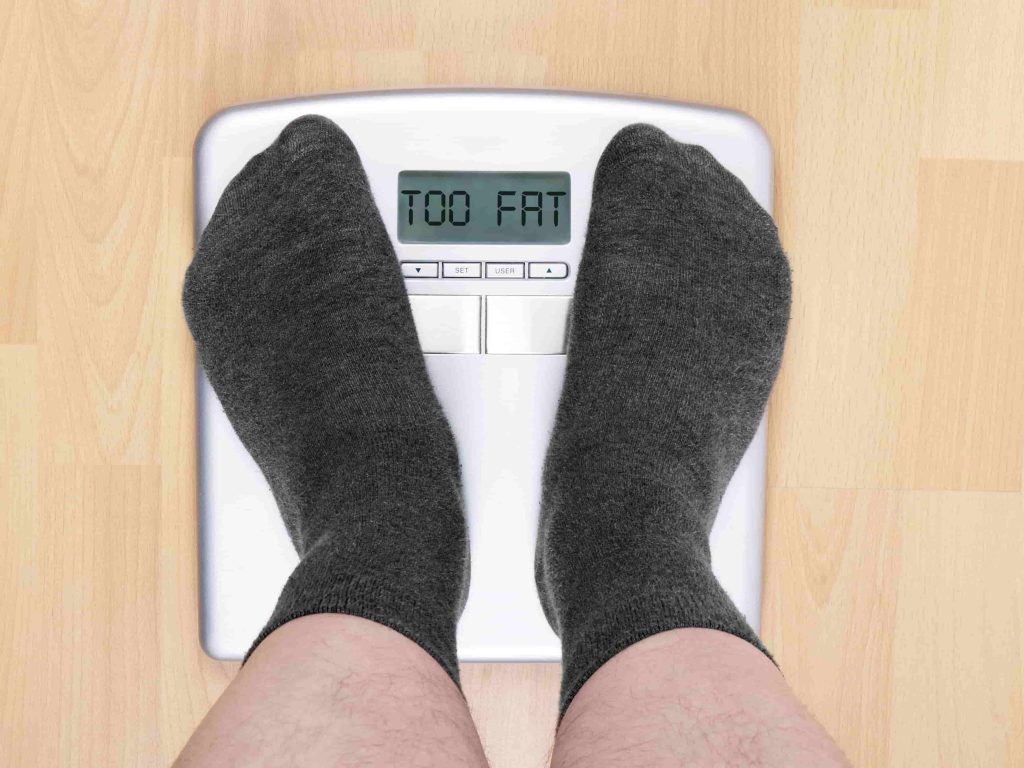 overweight man on personal scales display reads t 2021 08 30 14 34 55 utc min