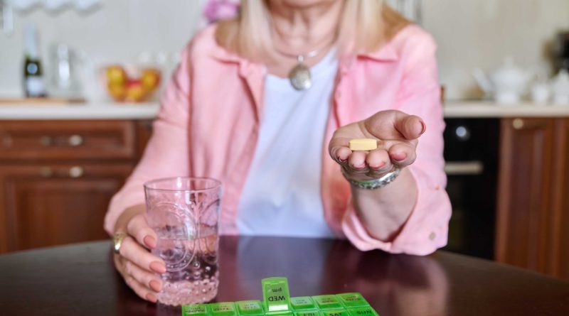 senior woman taking vitamins from daily pill box 2022 06 13 20 03 13 utc min 1 scaled